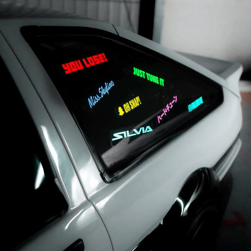 Underglow custom LED text decals on a white car rear window