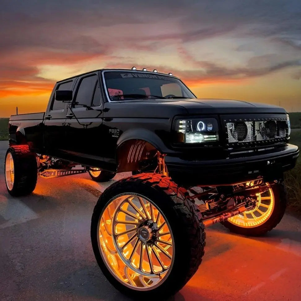 Black lifted Ford F-250 truck featuring Underglow orange wheel glow and underglow lighting.