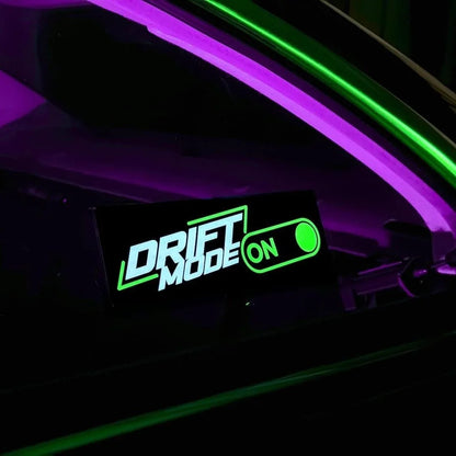 Underglow custom green LED decal displaying 'DRIFT MODE ON' inside a car interior.