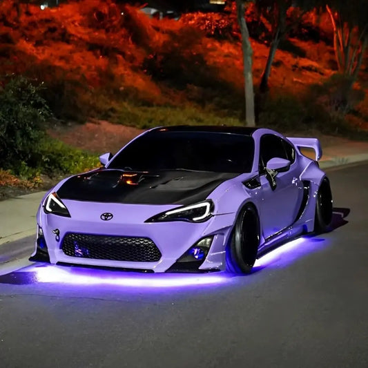 Lavender widebody Toyota 86 with black hood and purple Underglow LED underglow at night