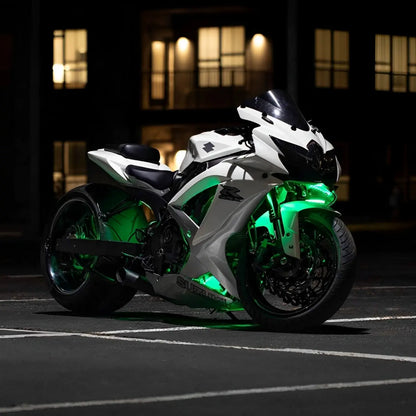 White Underglow motorcycle with bright green LED underglow lighting at night.